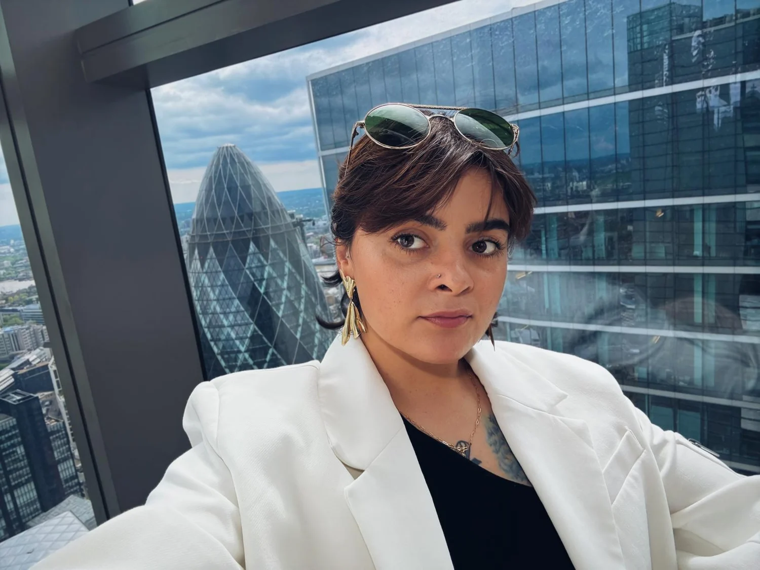 Andreea wearing a white blazer above the London skyline
