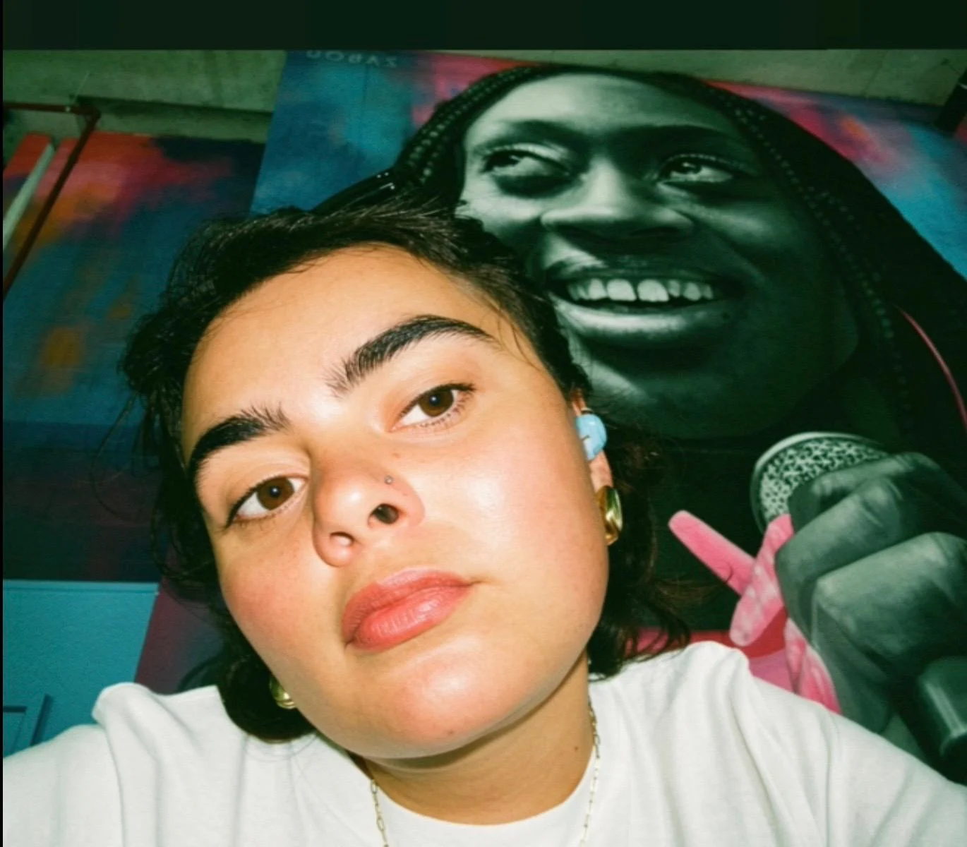 Andreea in front of a colourful music portrait