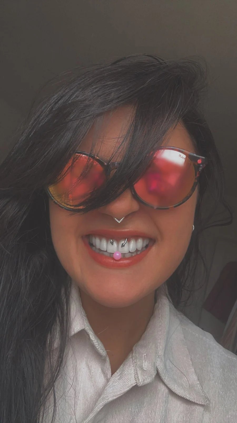 A smile behind red sunglasses